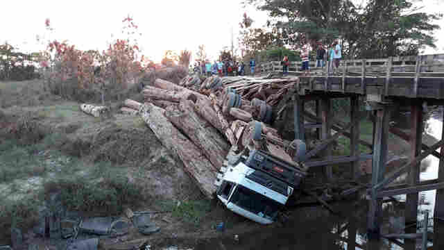 Ponte quebra e caminhão carregado com tora de madeira cai