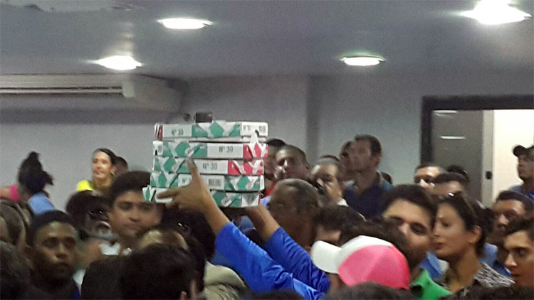Trabalhadores do transporte levam pizzas para a galeria da Câmara