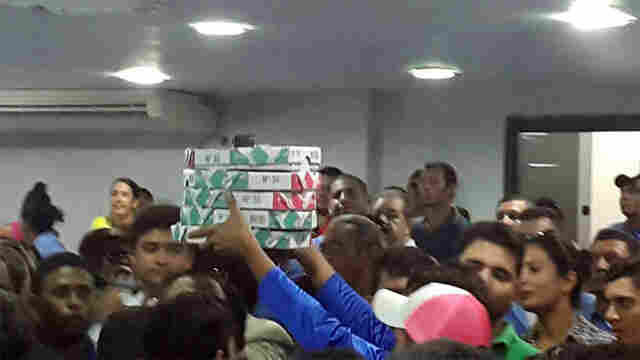 Trabalhadores do transporte levam pizzas para a galeria da Câmara