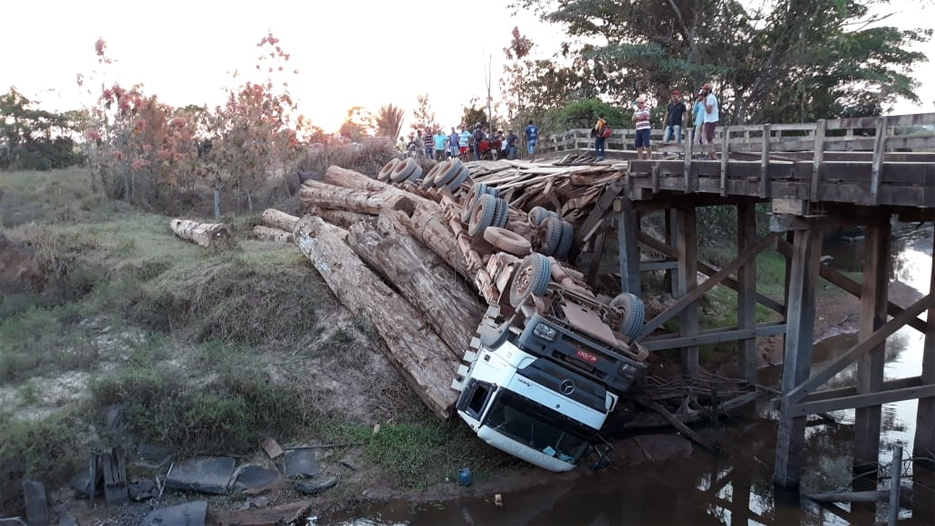 Ponte quebra e caminhão carregado com tora de madeira cai 