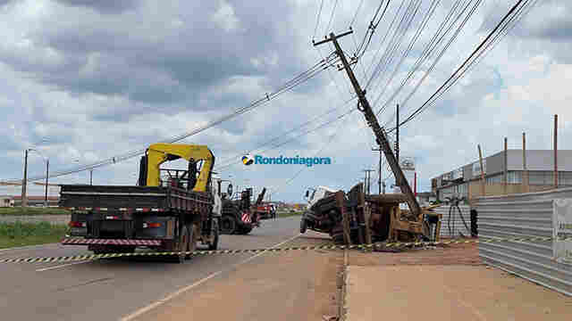 Caminhão transportando trator tomba e derruba poste em Porto Velho